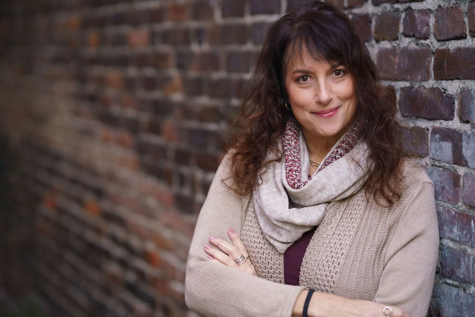 Issy Kleiman, MA, LMFT, smiling in front of a brick wall